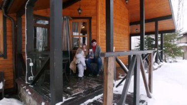 Güzel bir ev verandada sıcak içecekler içme küçük bir bebek ile genç mutlu aile