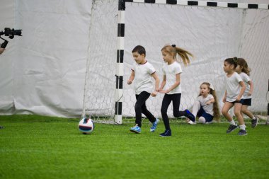 Çocuklar kapalı futbol oynuyor. Topu doğru çalışan çocuklar