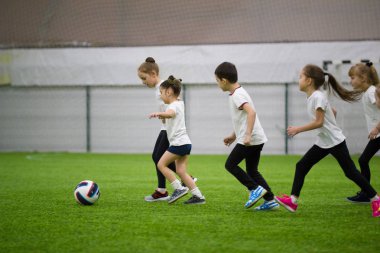 Çocuklar kapalı futbol oynuyor. Topu daha önce çalışan çocuklar