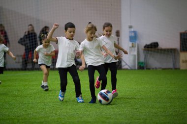Çocuklar kapalı futbol oynuyor. Çocuk topu kurşun
