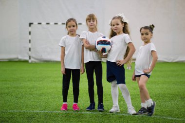 Çocuklar kapalı futbol oynuyor. Dört kız futbol takımı içerir
