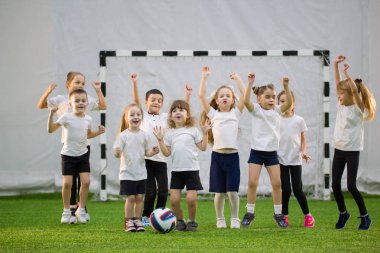 Sadece futbol kapalı çocuklar. Çocuk futbol takımı. Eller yukarı ve atlama
