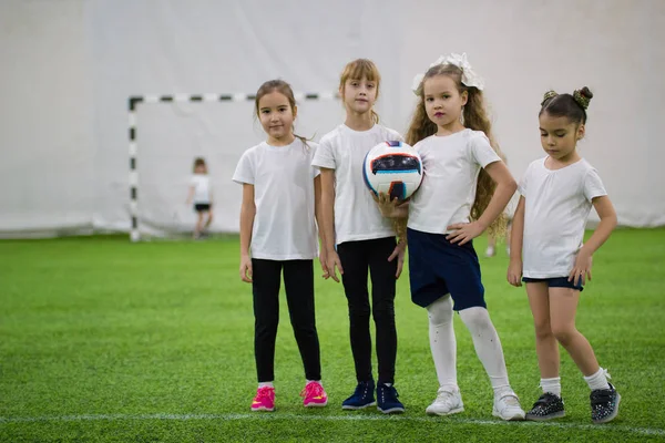 Children playing football indoors. Girls football team
