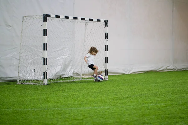 Fußball spielen in Innenräumen. Ein kleines Mädchen schützt erfolgreich Fußballtore — Stockfoto