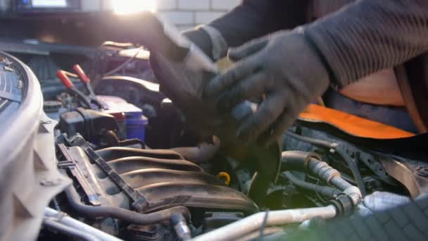 Car-service. En mekaniker man stänga en detalj inne i bilen — Stockvideo