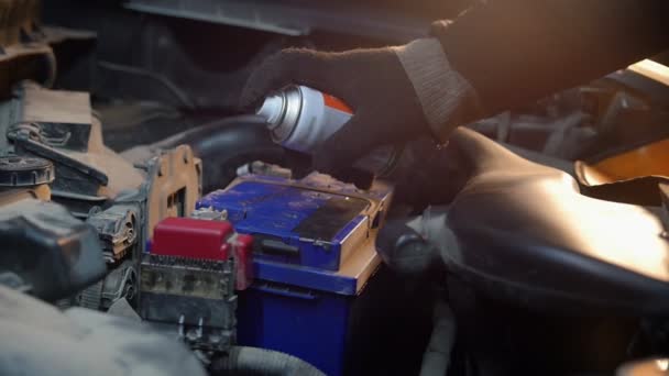 Servicio de coches. Un mecánico rociando pintura sobre la batería — Vídeo de stock