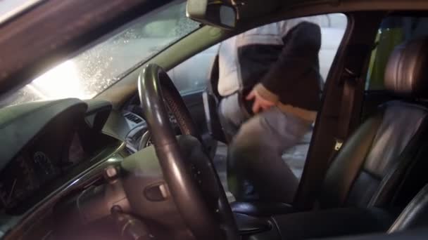 Автосервис. Толстый механик сидит в машине и открывает ноутбук — стоковое видео