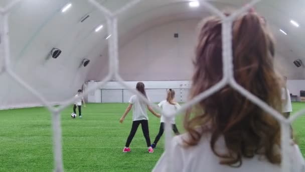 Arena de futebol interior. Miúdos a jogar futebol. Vista atrás da grade — Vídeo de Stock