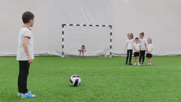 Campo da calcio al coperto. Bambini che giocano a football. Una bambina che protegge i cancelli — Video Stock