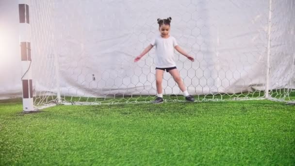 Halový fotbal aréna. Malá holčička chrání fotbalové branky — Stock video