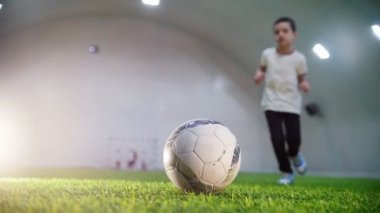Kapalı futbol arena. Baloya, çalışan küçük bir çocuk alır o elleri ve kaçmak
