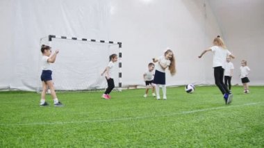 Kapalı futbol arena. Mutlu küçük çocuklar oynarken yakar top