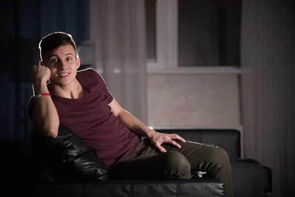 Ung attraktiv leende kille på soffan — Stockfoto