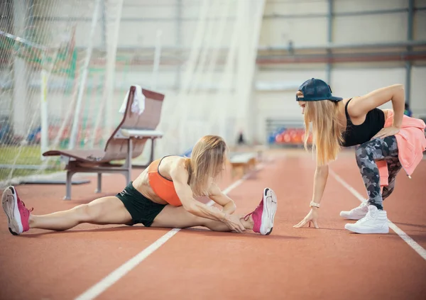 Due giovani donne atletiche che si allungano e si preparano a correre — Foto Stock
