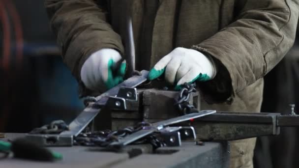 Conceito industrial. Um homem trabalhador colocar correntes dentro da parte de detalhe de metal — Vídeo de Stock