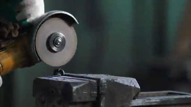 Lavoratore tagliare una catena nera con un macinino. Spara scintille — Video Stock