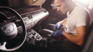 Araba Servisi. Genç bir adam araba panel otomatik bir fırça ile temizlik