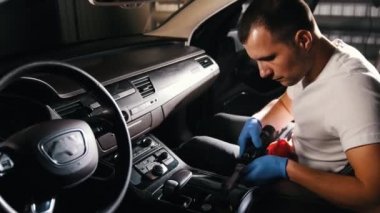 Araba Servisi. Genç bir adam araba panel otomatik bir fırça ile parlatma