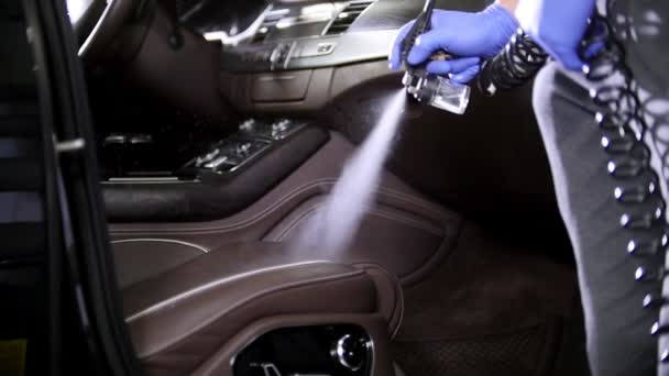 Car service. Spraying the cleaning agent on leather seat inside the car — Stock Video