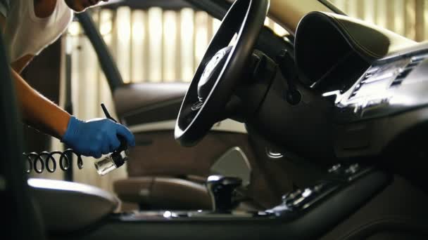 Pulverización del agente de limpieza en el asiento de cuero dentro del coche. Interior del coche — Vídeos de Stock