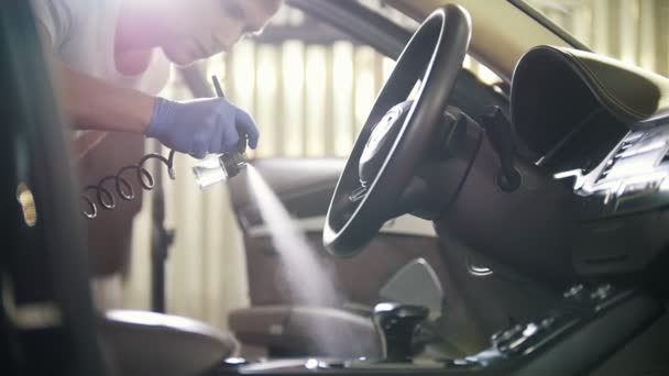 Servicio de coches. Pulverización del agente de limpieza en el asiento de cuero dentro del coche. Interior del coche — Vídeos de Stock