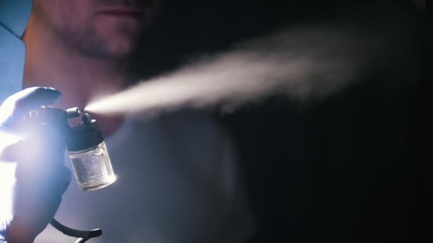 A man using a cleansing machine. Release the water stream on a black background. Spraying non-stop — Stock Video