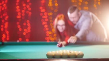 Bilardo oynarken bir çift. Bir kadın görücü usulü topları tatili