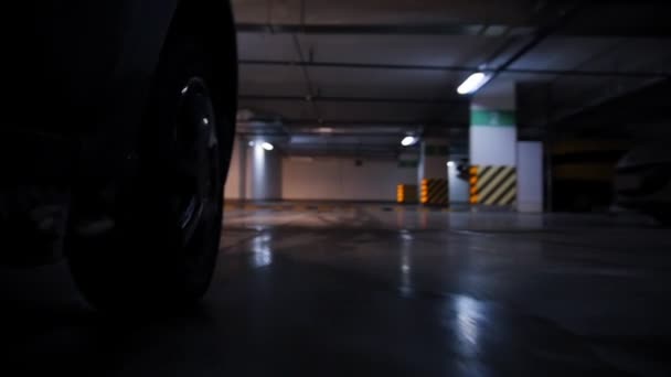 Parking souterrain. Roue de voiture en mouvement dans le cadre. Surmonter la bosse de vitesse — Video
