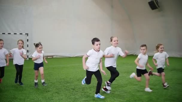Gyerekek focizni a Teremlabdarúgás arénában. Futás — Stock videók