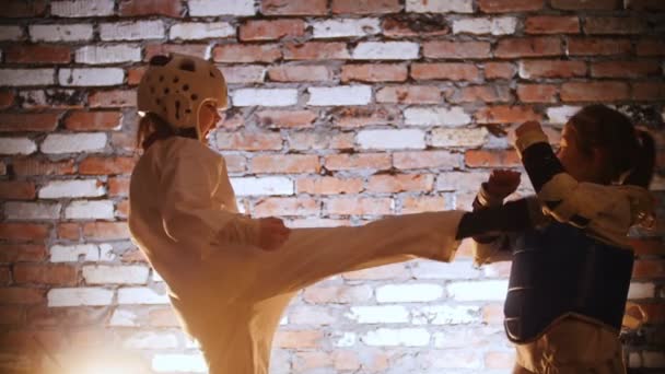 Учебная студия Боевые искусства. Девушка, тренирующая карате, бьет свою сестру. — стоковое видео