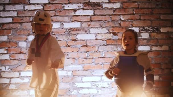 Studio szkoleń. Sztuki walki. Dwie małe dziewczynki podchodzi do kamery, pokaz karate trików — Wideo stockowe
