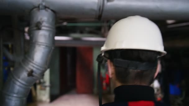 Un homme ingénieur dans un casque marchant dans une usine de fabrication — Video