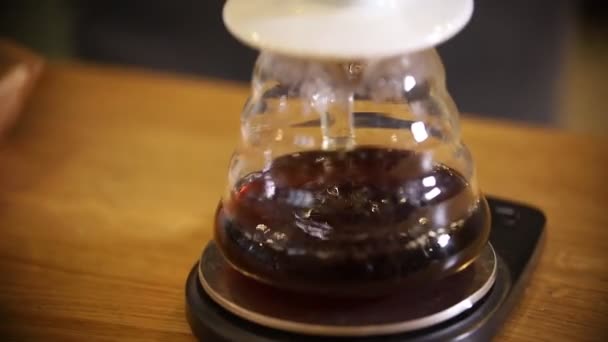 Barista kahve Amerikalı bir huni kullanarak alternatif bir yöntem yapma. Çaydanlık içinde bir filtre üzerinden dökülen bir americano — Stok video
