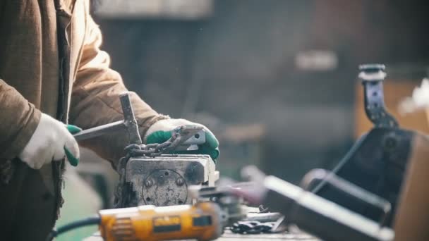 Conceito industrial. Um homem trabalhador martelando uma cadeia negra — Vídeo de Stock