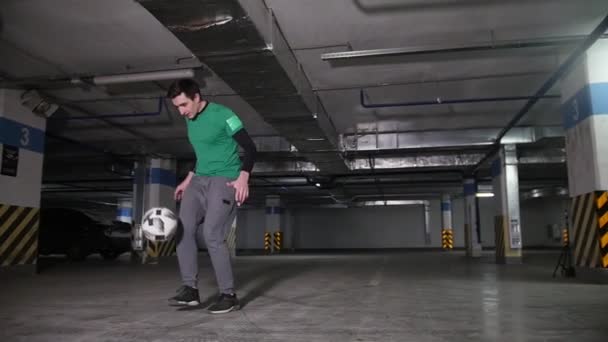 一个年轻人在地下停车场训练他的足球技巧技能 — 图库视频影像