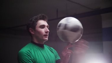 Yer altı otoparkı. Parmağını topa iplik bir genç futbol adam
