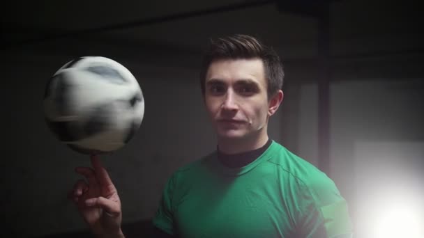 A soccer man spinning the football ball on his finger and looking in the camera — Stock Video