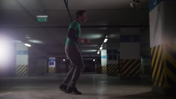 Estacionamento subterrâneo. Homem de futebol atlético treinando suas habilidades de futebol. Chutando a bola da parede — Vídeo de Stock