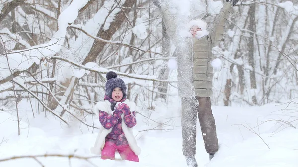 Twee kleine meisjes spelen met sneeuw in de winter forest. — Stockfoto