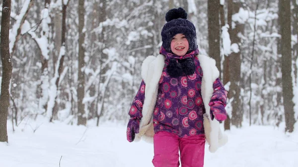 눈 겨울 숲에서 놀고 있는 어린 소녀. — 스톡 사진