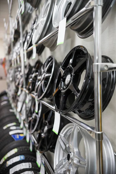 Nuovissimi cerchi moderni puliti sugli scaffali di un negozio di auto. Vista laterale — Foto Stock