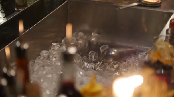 Bartender throws ice in a sink in the bar illuminated by candlelight — Stock Video