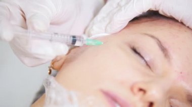Güzellik uzmanı Mezoterapi istemcileri yanak kozmetik kliniğinde enjeksiyon yapma yüz kozmetik prosedür yapıyor. Yakın çekim