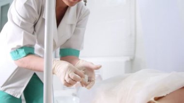 Doktor Iv.Hand damla sayacı kozmetik kliniğinde yatakta yatan bir kadın hasta hasta koyar. Mezoterapi
