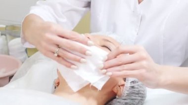 Kozmetik prosedürler kozmetik kliniğinde yüz temizleme işi krem istemciler üzerinde sürtünme güzellik uzmanı çene.