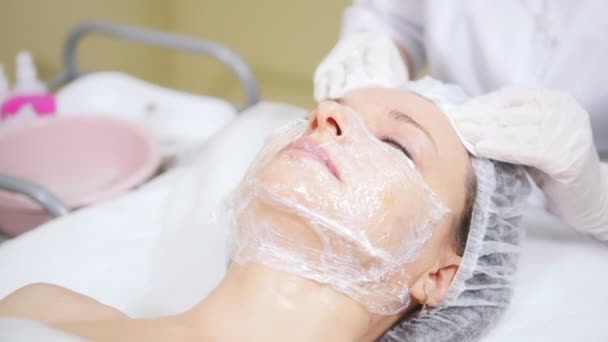 Kosmetikerin reinigt Gesicht ihrer Klienten bei kosmetischen Mesotherapie-Eingriffen in kosmetologischer Klinik. — Stockvideo