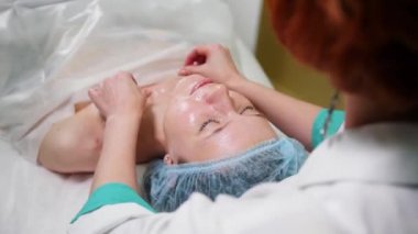 Masaj tedavisi kozmetik kliniğinde. Doktor özel yağ yüzünde smear