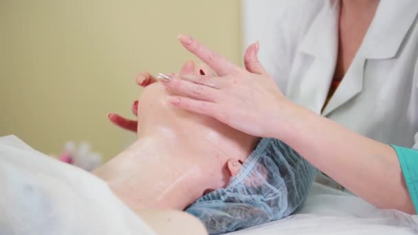 Un tratamiento de masaje facial en la clínica de cosmetología. Una mujer médico masajeando la sección de labios — Vídeo de stock