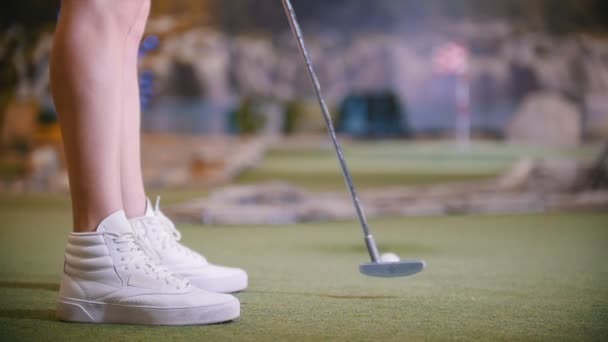Μια νεαρή γυναίκα παίζει μίνι γκολφ σε εσωτερικούς χώρους — Αρχείο Βίντεο