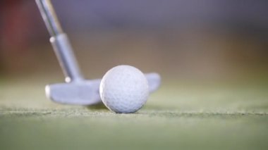 Mini golf oynuyor. Bir golf topu vurmak golf sopa. Yakın çekim